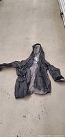 Black Misty Harbor rain coat laid flat showing exterior and hood