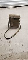 Vintage military field box phone in olive canvas carrying case with shoulder strap.