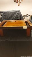 Photo showing full top view of old fashioned wooden serving tray or desk with raised edges and smooth wood surface.