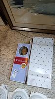 American Girl doll in original box with face visible and price tag attached.