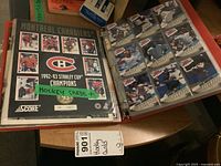 Photo of open red binder album with plastic sleeves holding vintage hockey cards including 1992-93 Score Montreal Canadiens Stanley Cup Champions folder