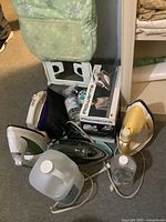 Full lot overview including ironing board, irons, starch jug
