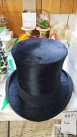 Front view of black silk top hat showing smooth silk surface and brim.