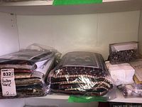 Three stacks of sealed quilting fabric kits and fabric bundles on shelf