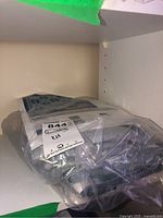 Photo showing sealed quilting kit with pattern and fabric pack in plastic wrapping on shelf.