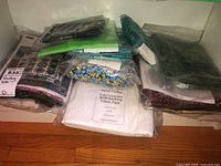 Photo of multiple sealed fabric packs for quilting including backing fabric and various pre-cut pieces.