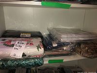 Six quilt backing fabrics arranged on a shelf in clear packaging