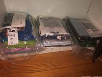 Three quilting kits wrapped in plastic, showing packaged fabric bundles and sewing patterns.