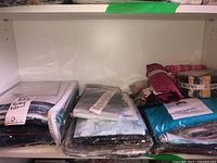Shelf view showing multiple quilting kits and precut fabric bundles in clear packaging