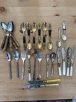 Top view of the entire cutlery lot showing spoons, forks, and knives arranged on a wooden surface.