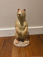 Front view of simulated wood bear statue standing upright.