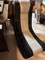 Gaming rocker chair with black and light gray upholstery, ergonomic curved design