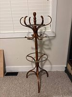 Front view of the wooden hat stand showing curved hooks and circular metal ring.