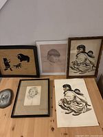 Wide shot of all artwork including framed and unframed drawings and a textile art piece