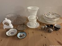 Full overview of all items including milk glass clock, glass celery tray, cups, porcelain dishes, and nickel silver condiment holders