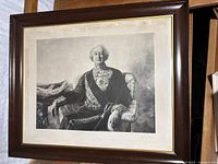 Full view of framed print depicting Sir John A. Macdonald in formal attire sitting on a chair.
