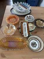 Overview of various dishes including glass bowls, ashtrays, and ceramic small plates on wooden table