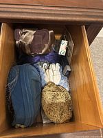 Drawer containing vintage hats, gloves, coin purses, and cologne bottle