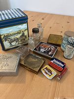 Overview of all vintage tins and glass containers on table.