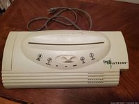 Top view of compact white plastic paper shredder with control switches and power cord.