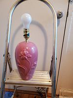 Photo of dusty rose ceramic lamp on metal step stool showing lamp body and floral detail