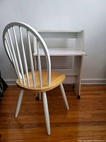 Side view of Windsor chair in front of white mini desk on hardwood floor