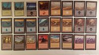 All 24 black-border land cards laid out in three rows