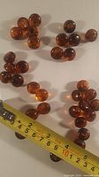 All 31 Bakelite buttons grouped by size beside tape measure
