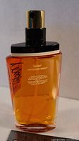 Front view of Mackie eau de toilette tester bottle showing amber liquid and spray nozzle