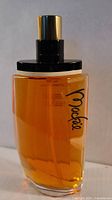 Front view of Mackie perfume bottle showing logo and amber liquid