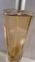 Front view of Nicole by Nicole Miller bottle showing brand name and amber liquid