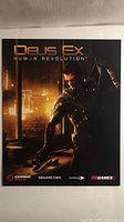 Front view of Deus Ex: Human Revolution cover art showing Adam Jensen and logos