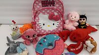 Group shot of all plush toys and Hello Kitty backpack