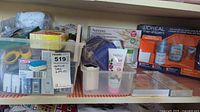 Overview of plastic containers with health care supplies and various toiletry products including Aveeno and Yardley items on tabletop