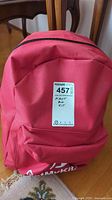 Red backpack labeled ‘First Aid Kit’ with Maxsold sticker