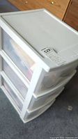 White plastic storage unit from a top angle showing the three transparent drawers.
