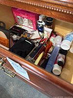 Drawer with various skin care items such as tubes, bottles, and boxed hand creams.