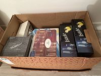 Box containing multiple boxed glassware items including Cristal Brilliance collection, highball glasses, and other crystal glassware.