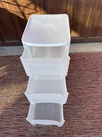 Front view showing three white plastic drawers open.