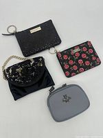 Four change purses arranged together showing varying designs, colors, and materials.