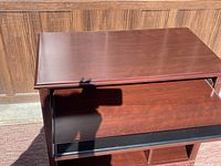 Top view of rolling computer and printer table showing cherry finish and smooth surface with light scratches.