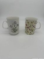 Front view of two Rose of England mugs with floral patterns, showing their shape and design.