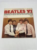 Front cover photo of Beatles VI vinyl LP showing the four Beatles smiling, good condition with visible wear.