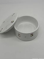 White ceramic lidded bowl with small pink flowers around sides and lid