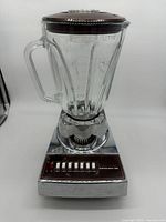 Front view of vintage Hamilton Beach Scovill blender showing clear glass pitcher with handle and chrome base with 14 push-button speed controls.