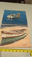 Top view of both 8x10 oil paintings showing boats on water with ruler for scale.