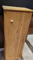 Full front view of pine wood cabinet showing door and wooden knob.