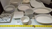 Entire set of white serveware with CorningWare pieces, soup bowls, plates, and trays displayed together.