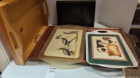 Three serving trays visible on a table, wooden trays and one plastic tray with animal designs