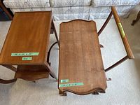 Two wooden vintage tables and a wooden towel rack displayed on carpeted floor with a couch background.